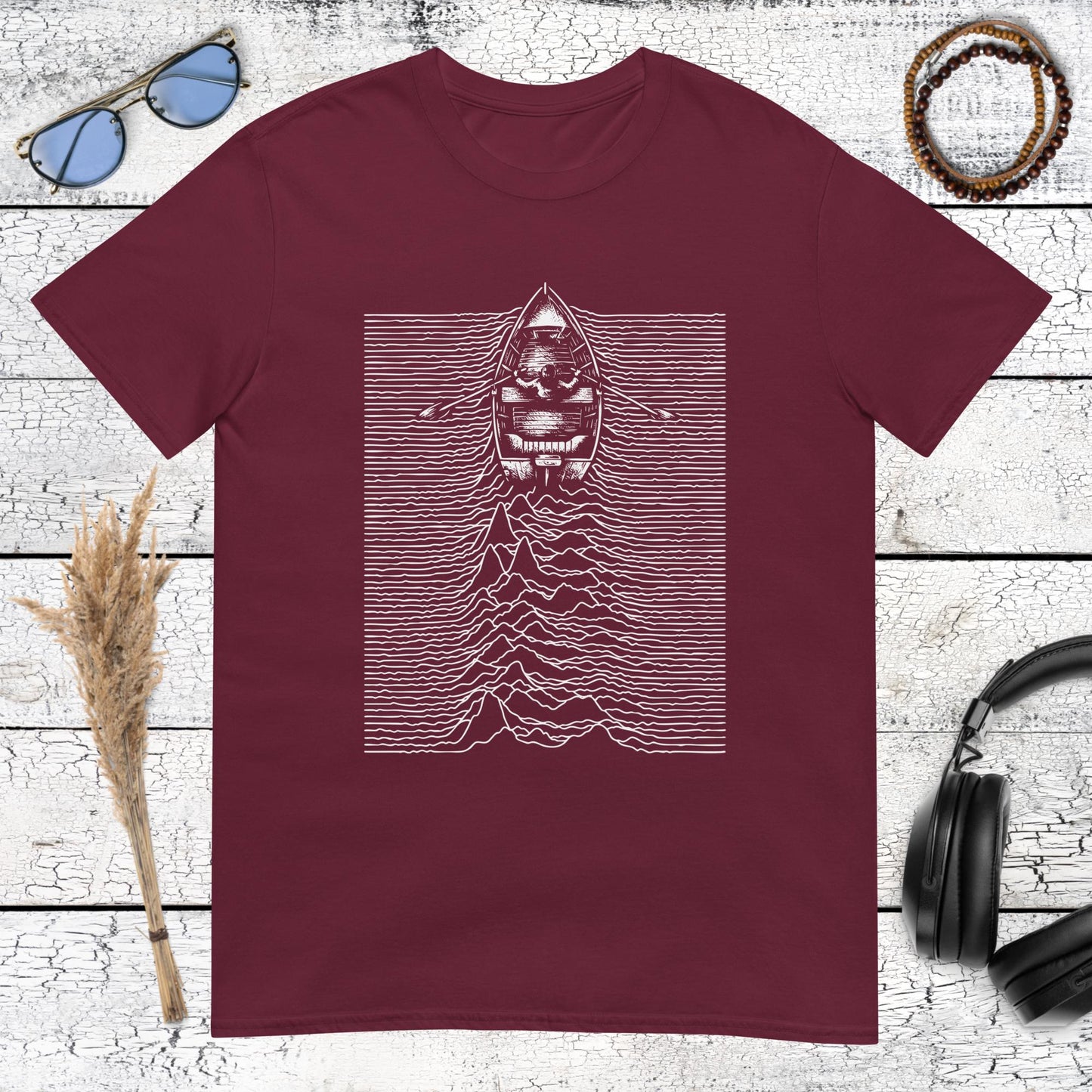 Minimalist solitary boat graphic with retro music-inspired lines on a maroon t-shirt