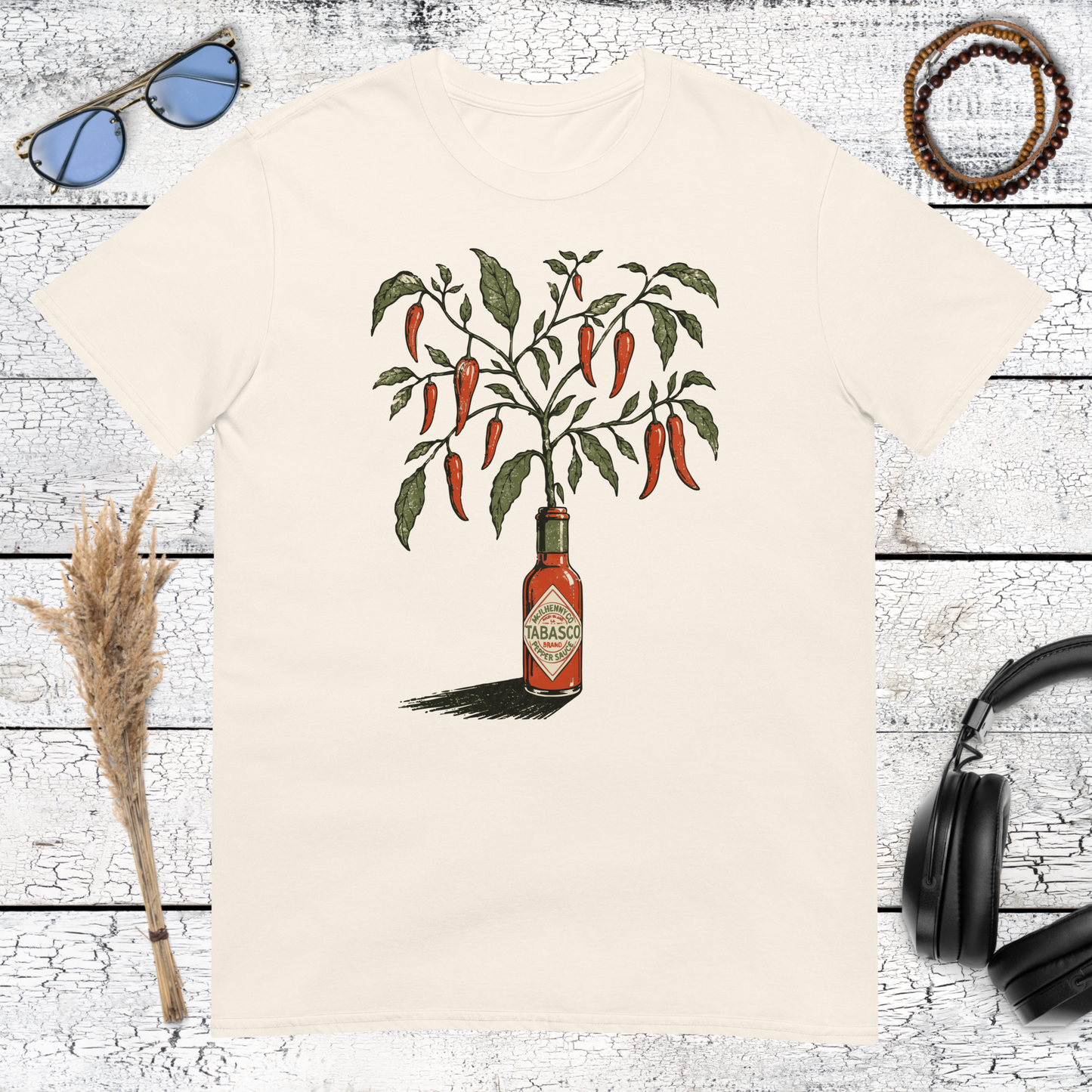 Vintage-style chili pepper plant growing out of a hot sauce bottle on a natural cotton t-shirt