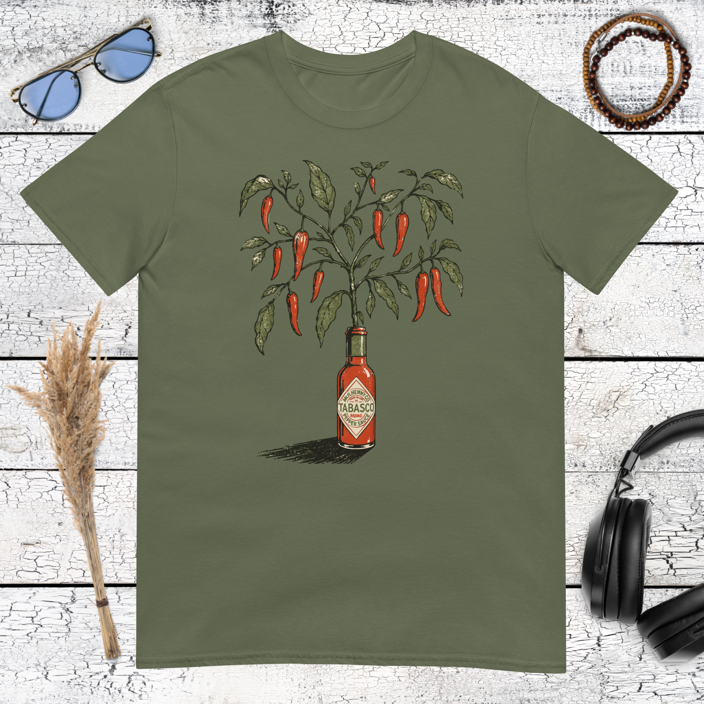 Botanical hot sauce bottle with red chili peppers and green leaves printed on a military green t-shirt