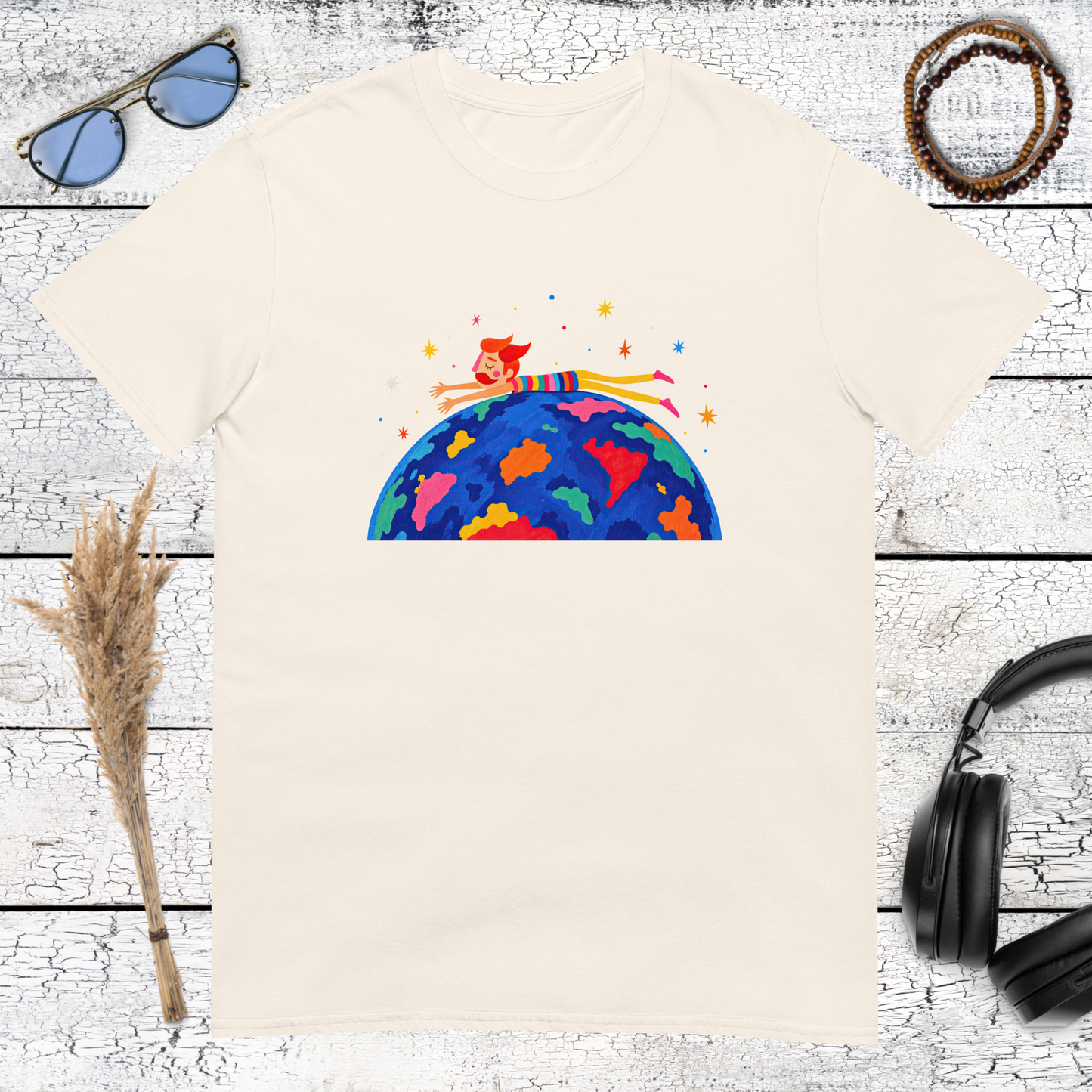 Small human figure riding a colourful planet Earth in space on a natural cotton t-shirt