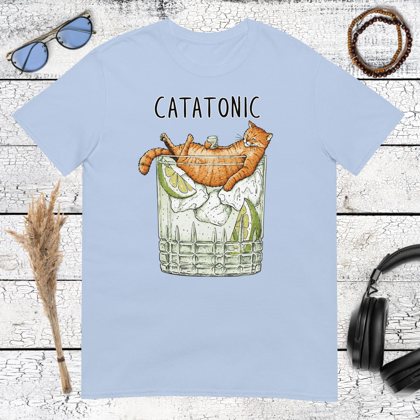 Funny cat holding a cocktail with retro Catatonic lettering on a light blue t-shirt
