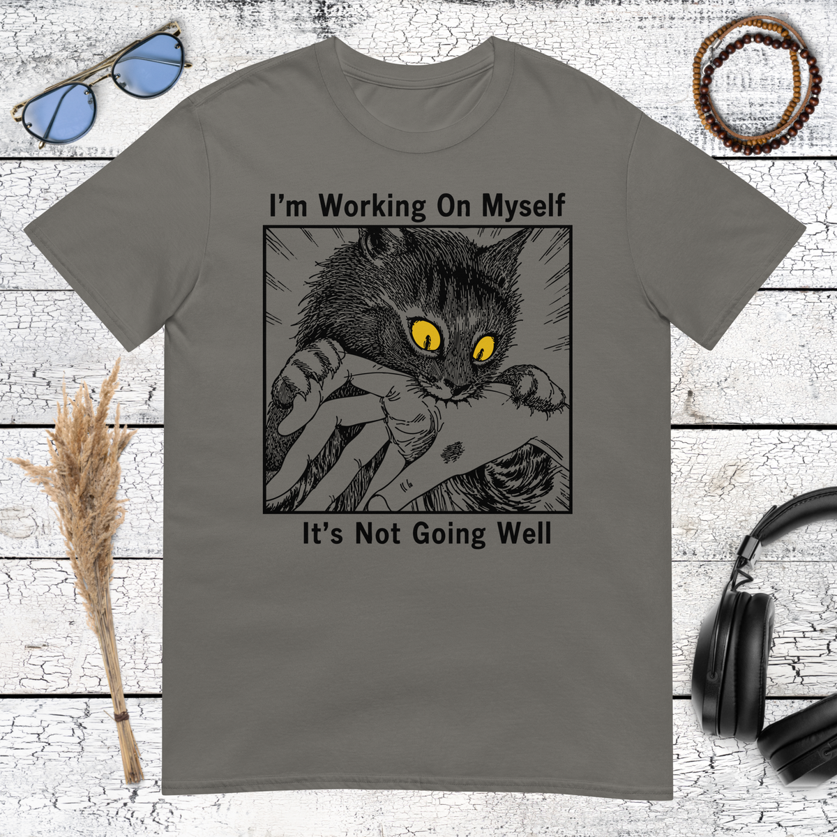 Humorous cat graphic with sarcastic self improvement quote on a charcoal t-shirt