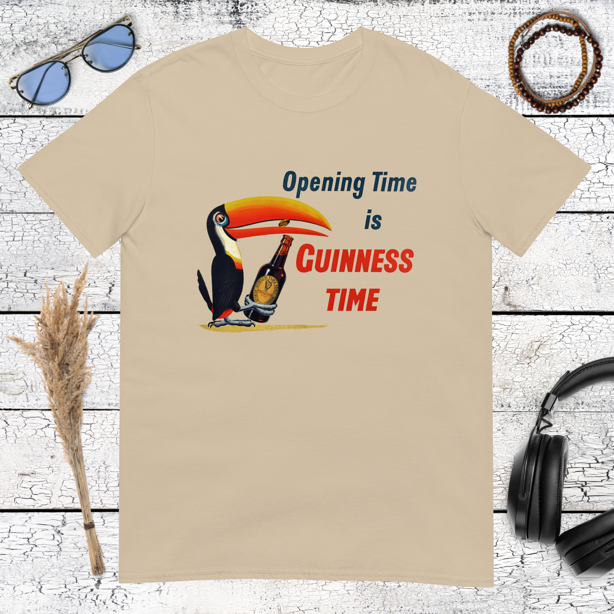 Colourful Guinness toucan holding a beer glass with retro pub lettering on a sand t-shirt