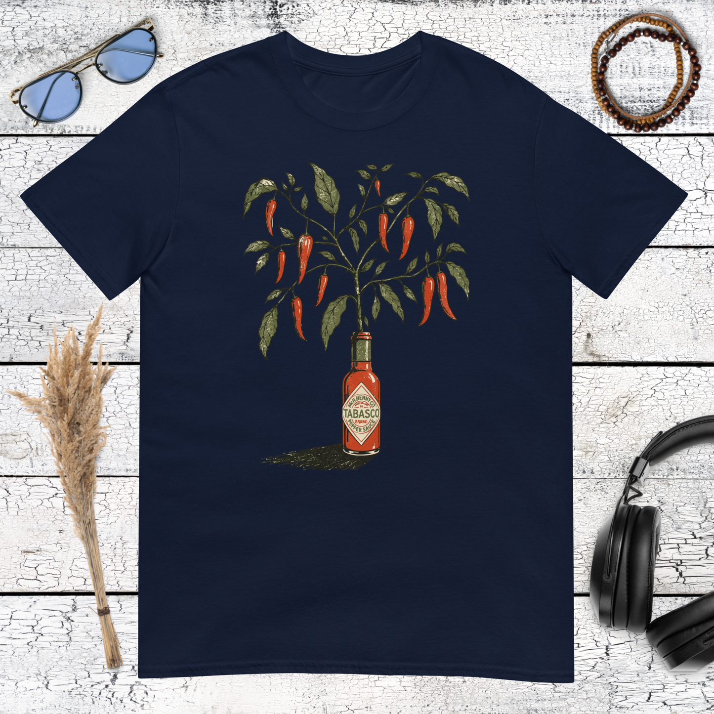 Vintage hot sauce bottle growing into a chili pepper plant printed on a navy blue t-shirt