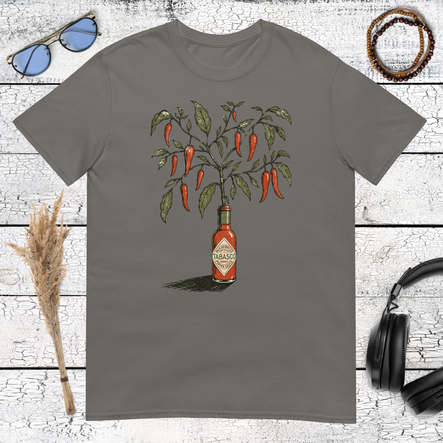 Detailed red chili peppers and hot sauce bottle artwork printed on a charcoal t-shirt