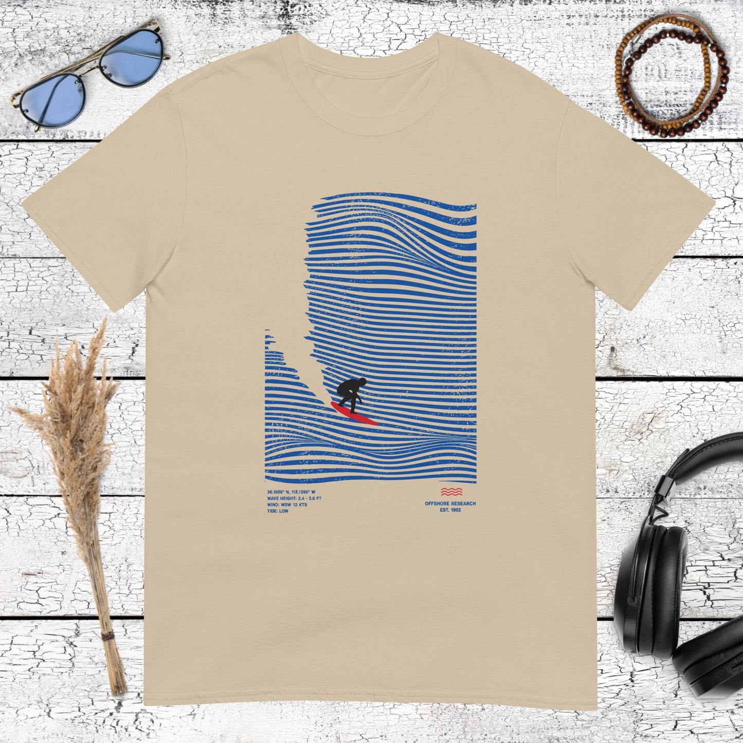 Retro style surfer character on blue waves on a sand colored shirt
