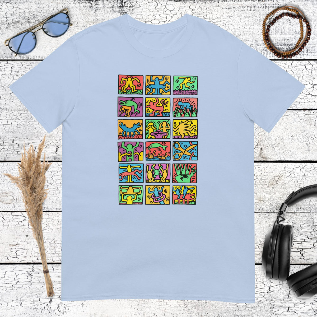 Light blue t-shirt featuring a playful Keith Haring style collage